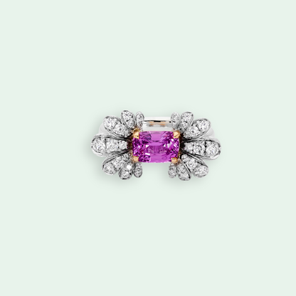 Diamond-encrusted ring with a pink gemstone on a light gray background